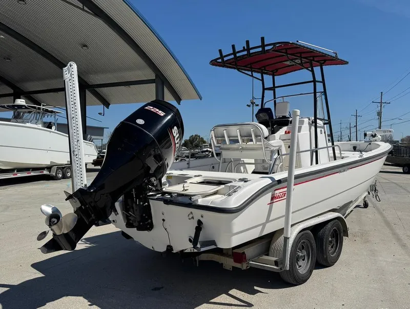 Slide: The Image of 2002 Boston Whaler 220 Dauntless boat on trailer, outdoor setting, clear sky. - 7