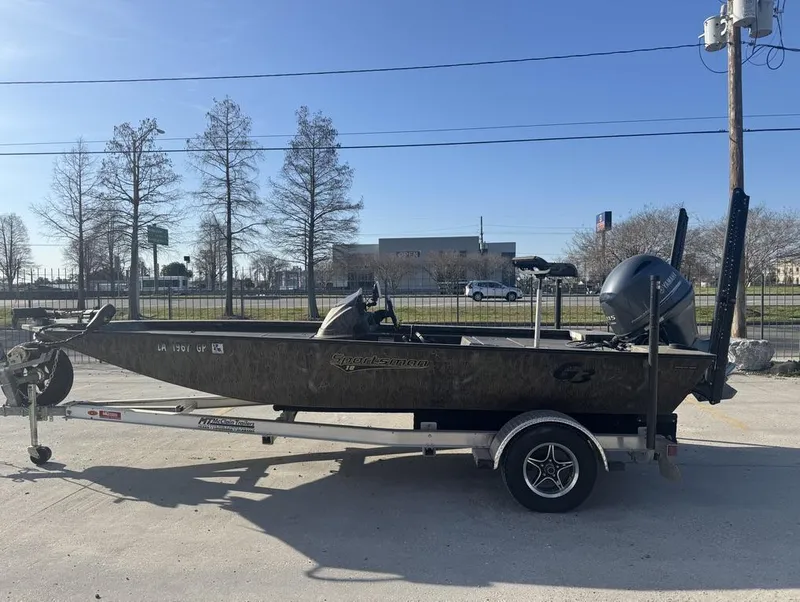 Slide: The Image of 2018 G3 Sportsman 18 Camo boat on trailer, parked outdoors. - 14