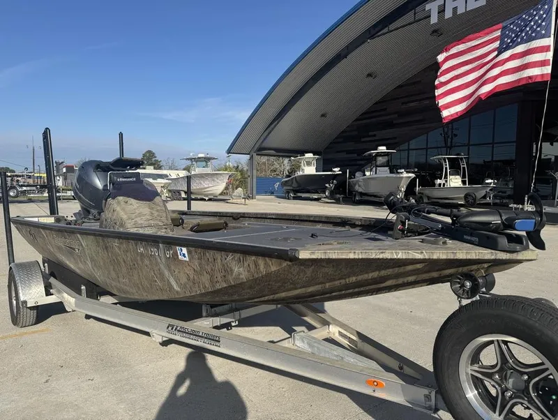 Slide: The Image of 2018 G3 Sportsman 18 Camo boat on trailer, displayed outdoors with American flag. - 6