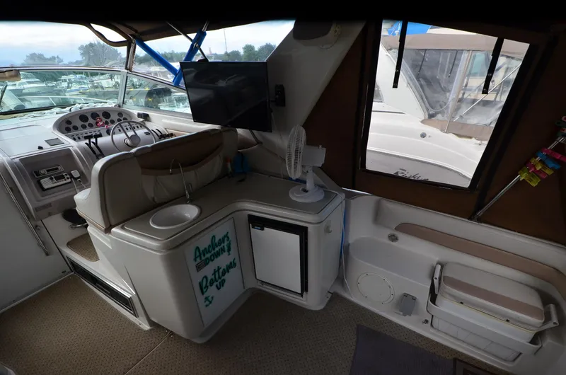 Slide: The Image of Interior of a 1994 Regal Commodore 400 boat with helm, seating, and mini fridge. - 17