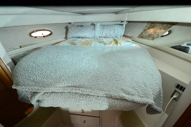 Slide: The Image of Cozy cabin interior of 1994 Regal Commodore 400 with plush bedding and porthole windows. - 19