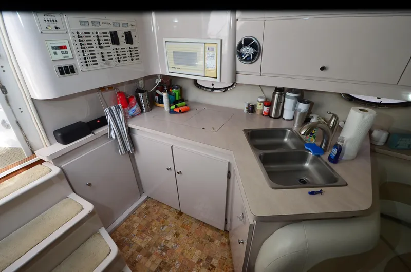 Slide: The Image of 1994 Regal Commodore 400 yacht kitchen with dual sinks, control panel, and storage cabinets. - 20