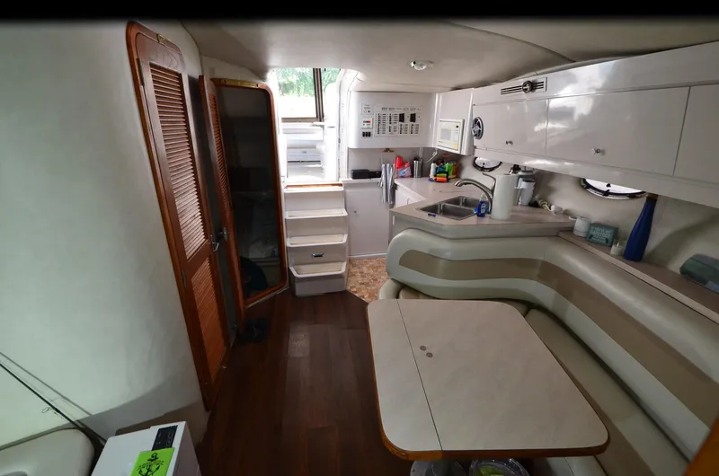 Slide: The Image of 1994 Regal Commodore 400 yacht interior with kitchenette, dining area, and wooden flooring. - 22