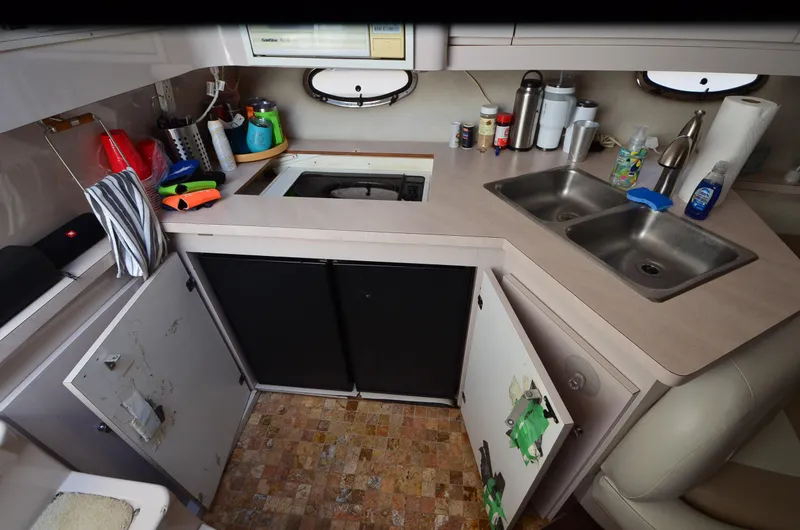 Slide: The Image of 1994 Regal Commodore 400 boat kitchen with sink, stove, and storage cabinets. - 29