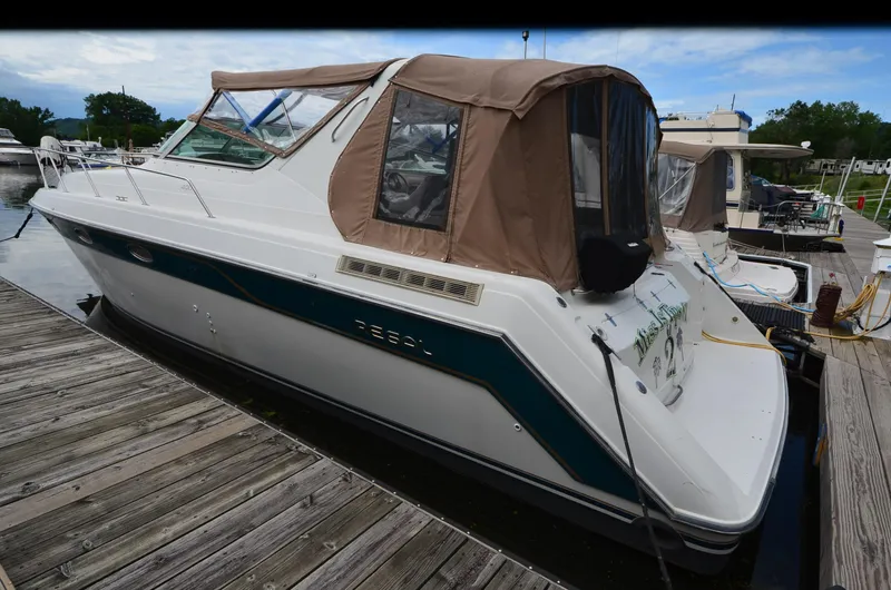 Slide: The Image of 1994 Regal Commodore 400 boat docked at a marina with a brown canopy. - 3