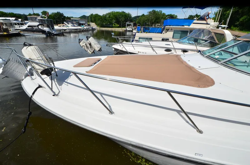 Slide: The Image of 1994 Regal Commodore 400 boat docked at marina, featuring sleek design and tan cover. - 31