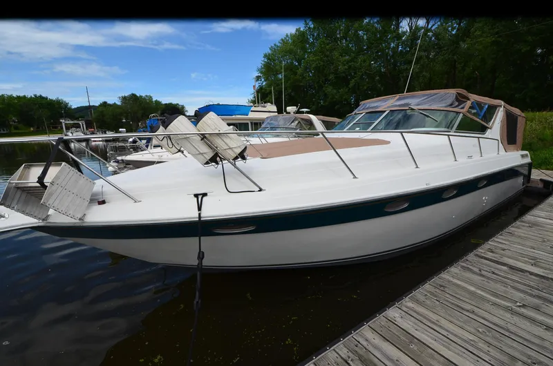 Slide: The Image of 1994 Regal Commodore 400 boat docked at marina, featuring sleek design and spacious deck. - 4