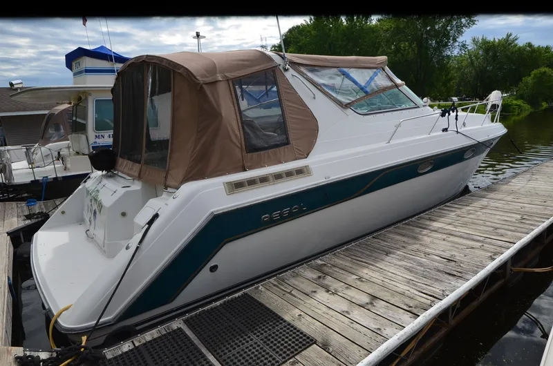 Slide: The Image of 1994 Regal Commodore 400 boat docked, featuring a white hull and brown canopy. - 6