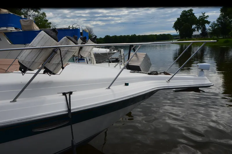 Slide: The Image of 1994 Regal Commodore 400 boat docked on a calm river with cloudy sky. - 8