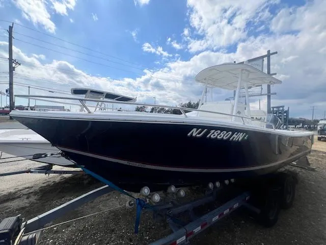 Slide: The Image of 2004 Regulator 24 Forward Seating boat on trailer under cloudy sky. - 0