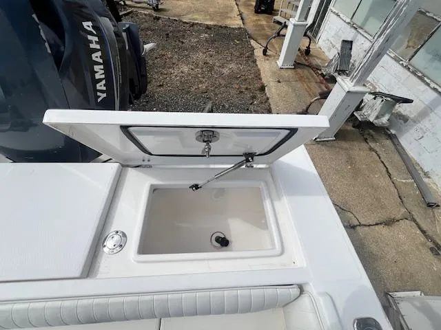 Slide: The Image of 2004 Regulator 24 Forward Seating boat with open storage compartment and Yamaha engine. - 15