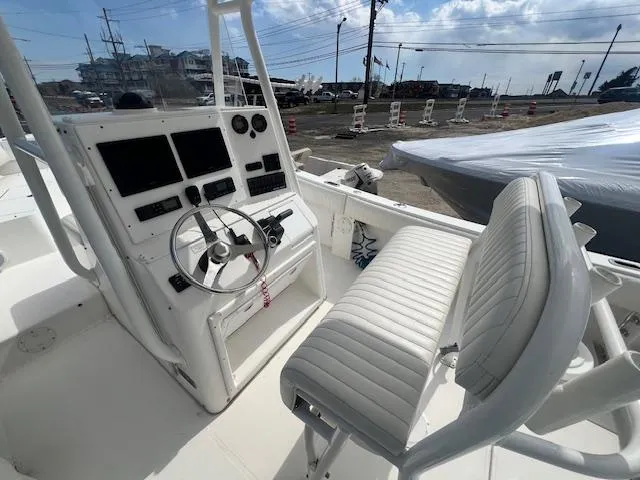 Slide: The Image of 2004 Regulator 24 Forward Seating boat interior with steering console and cushioned seating. - 2