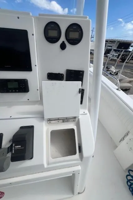 Slide: The Image of 2004 Regulator 24 Forward Seating boat dashboard with gauges and storage compartment. - 8