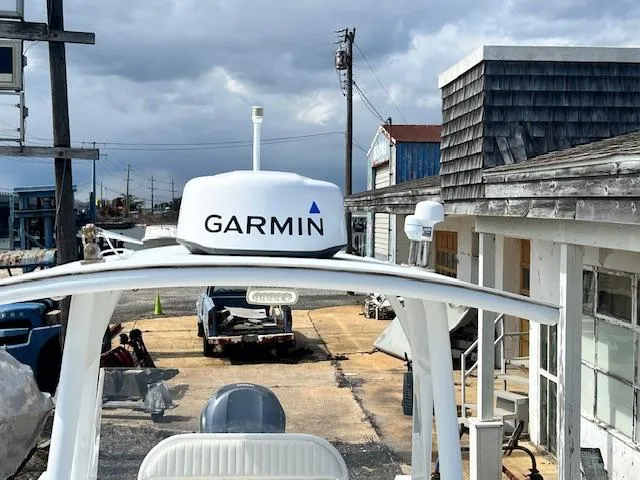 Slide: The Image of 2004 Regulator 24 Forward Seating boat with Garmin radar, docked near rustic buildings. - 9