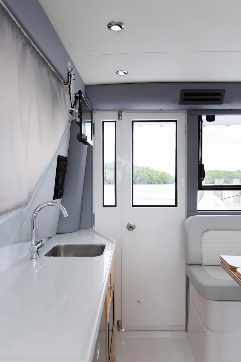 Slide: The Image of Interior of 2020 ArrowCat 320 Fly Dual Helm, featuring sleek kitchen and seating area. - 10