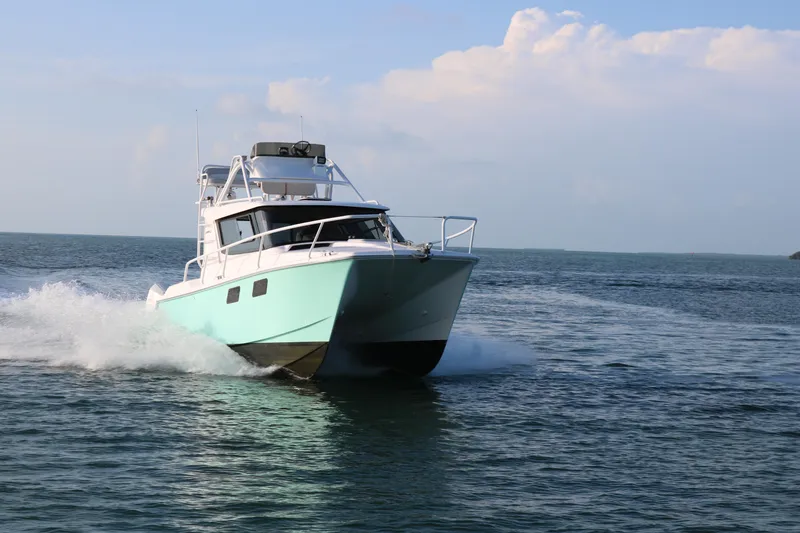 Slide: The Image of ArrowCat 320 Fly Dual Helm 2020 cruising on open water under clear skies. - 2