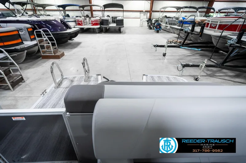 Slide: The Image of 2025 Bennington 21 SLJ pontoon boats in a showroom with various models displayed. - 18