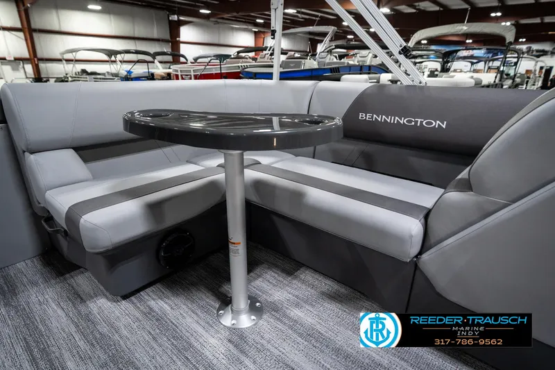 Slide: The Image of 2025 Bennington 21 SLJ boat interior with gray seating and table in showroom. - 26