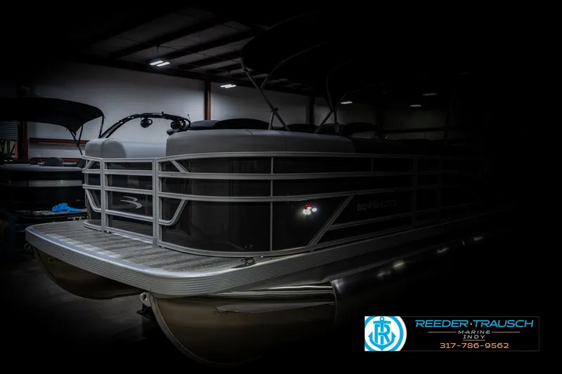 Slide: The Image of 2025 Bennington 21 SLJ pontoon boat in a dimly lit showroom. - 4