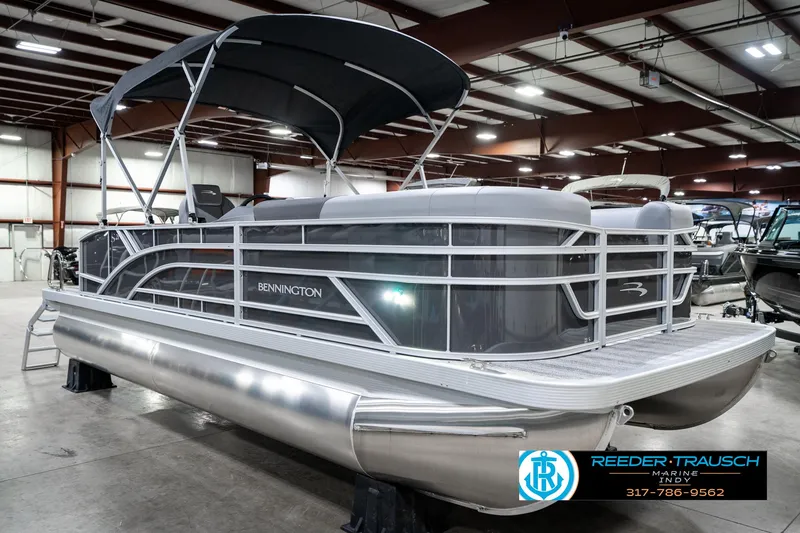Slide: The Image of 2025 Bennington 21 SLJ pontoon boat in showroom, featuring sleek design and canopy. - 6