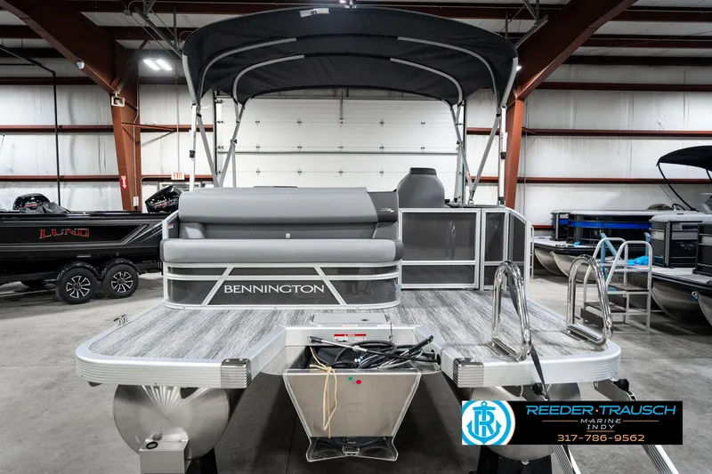 Slide: The Image of 2025 Bennington 21 SLJ pontoon boat in showroom with canopy and ladder. - 9
