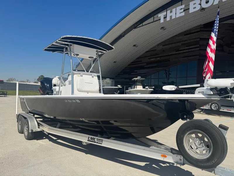 Slide: The Image of 2021 Sportsman Tournament 234 SBX Bay Boat on trailer, parked outside a building. - 5