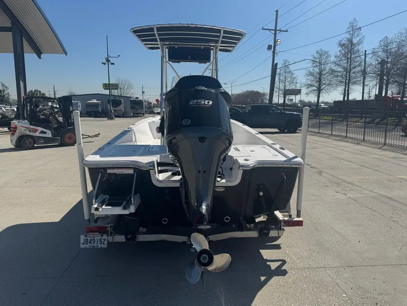 Slide: The Image of 2021 Sportsman Tournament 234 SBX Bay Boat with powerful outboard motor, parked outdoors. - 8
