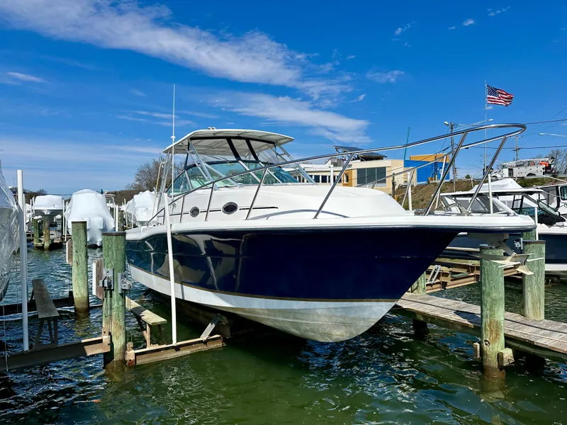 Slide: The Image of 2005 Stamas 320 Express boat docked at a marina under a clear blue sky. - 0