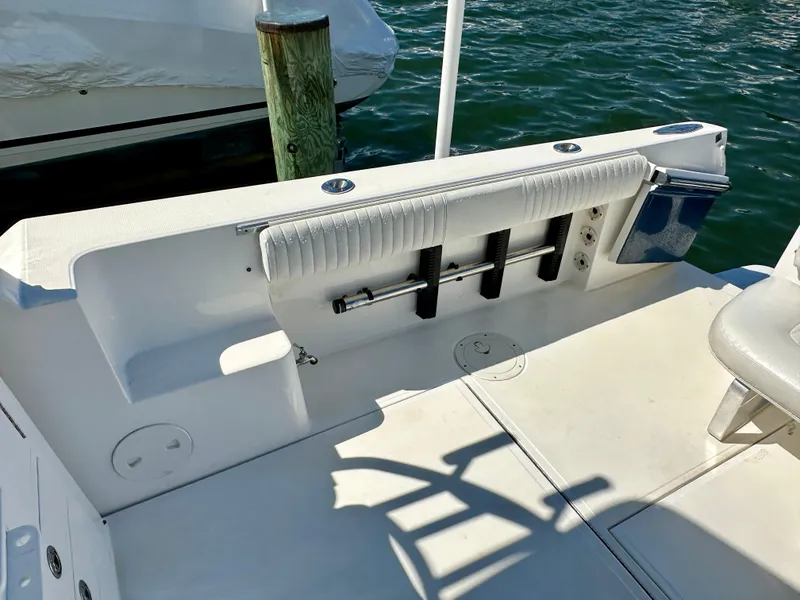 Slide: The Image of 2005 Stamas 320 Express boat deck with rod holders and seating, docked by the water. - 18
