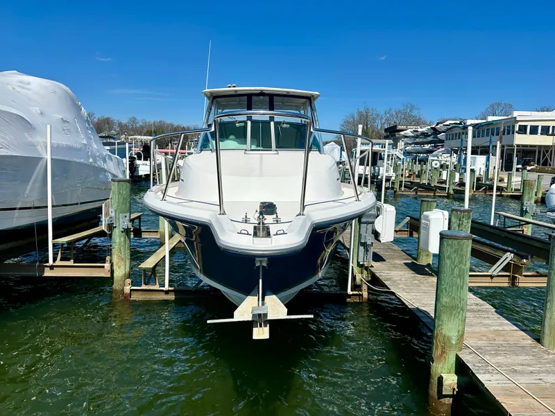 Slide: The Image of 2005 Stamas 320 Express boat docked at a marina, front view. - 2