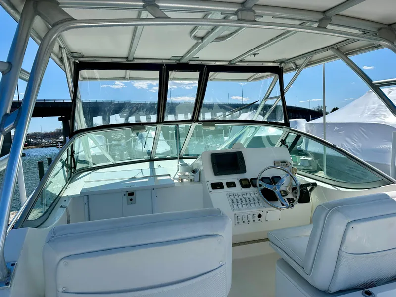 Slide: The Image of 2005 Stamas 320 Express boat cockpit with steering wheel and control panel, docked by a bridge. - 20