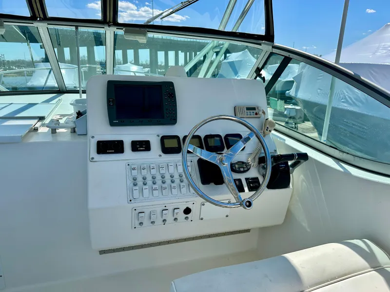 Slide: The Image of 2005 Stamas 320 Express boat helm with steering wheel and control panel. - 21