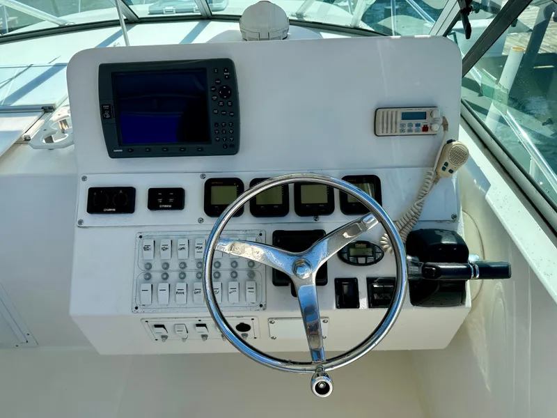 Slide: The Image of Control panel of a 2005 Stamas 320 Express boat with steering wheel and navigation equipment. - 22