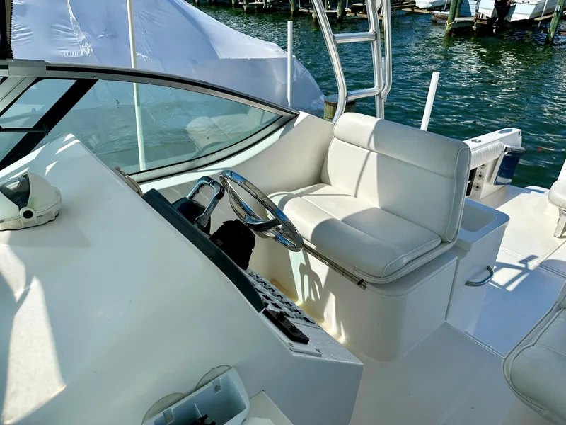Slide: The Image of 2005 Stamas 320 Express boat helm with white seating and steering wheel. - 25