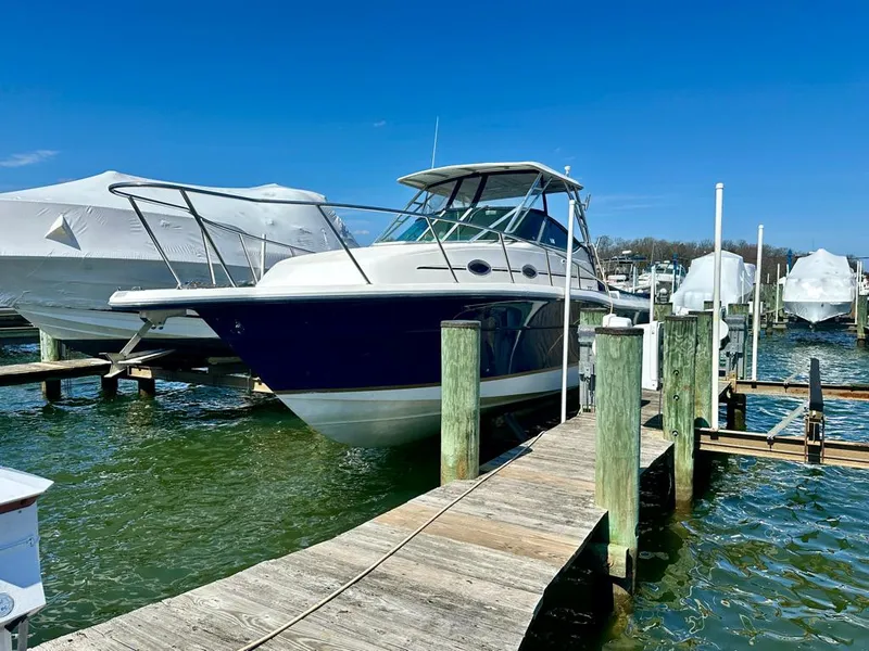 Slide: The Image of 2005 Stamas 320 Express boat docked at a marina under clear blue skies. - 3
