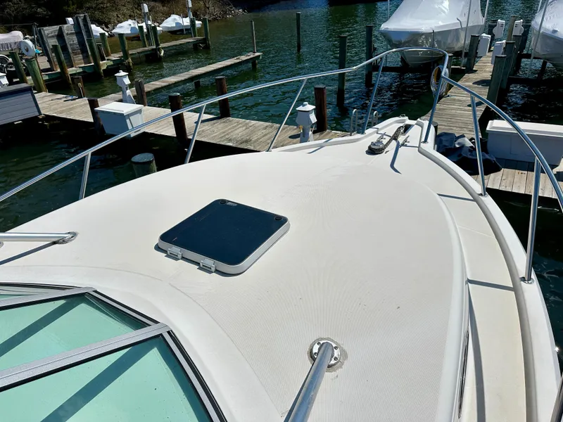 Slide: The Image of 2005 Stamas 320 Express boat docked, showcasing bow and deck features. - 30