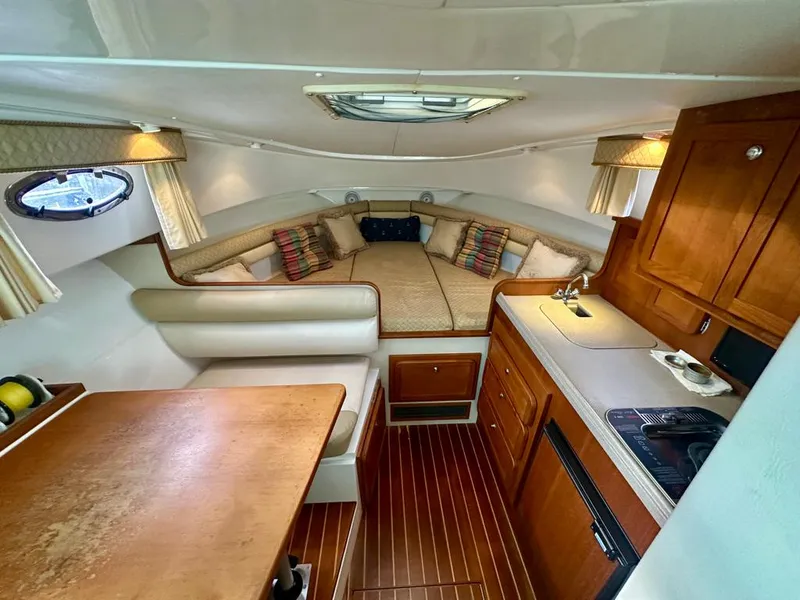 Slide: The Image of 2005 Stamas 320 Express cabin interior with cozy seating, kitchenette, and wood accents. - 33