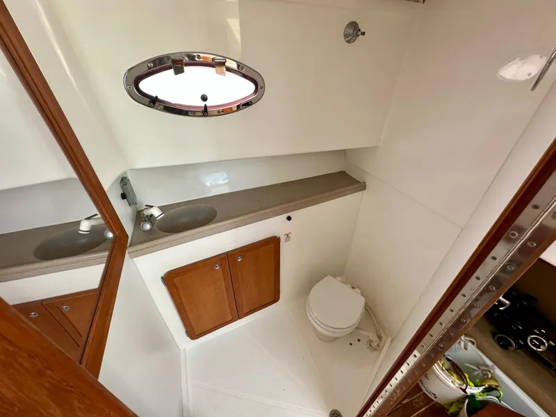 Slide: The Image of 2005 Stamas 320 Express boat bathroom with sink, toilet, and wooden cabinets. - 37