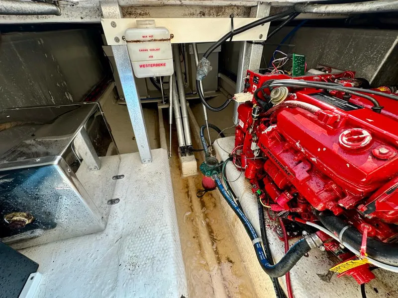 Slide: The Image of Engine compartment of a 2005 Stamas 320 Express boat, featuring a red engine and wiring. - 39