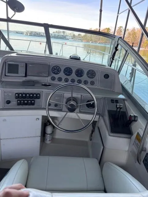 Slide: The Image of 1997 Formula 34PC boat helm with steering wheel, gauges, and controls on a sunny day. - 10