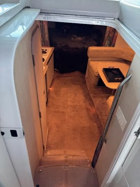 Slide: The Image of Interior view of a 1997 Formula 34PC boat, featuring a cozy seating area and kitchenette. - 12