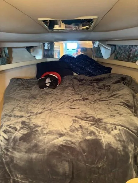 Slide: The Image of Cozy cabin interior of a 1997 Formula 34PC boat with plush bedding. - 13
