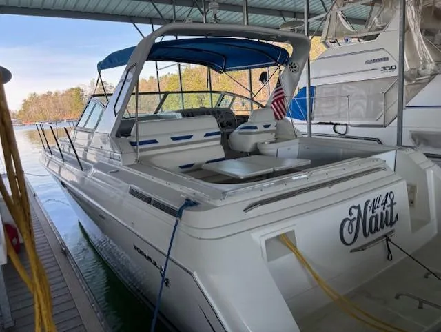 Slide: The Image of 1997 Formula 34PC boat docked, featuring a blue canopy and American flag. - 4