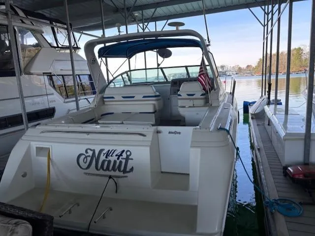 Slide: The Image of 1997 Formula 34PC boat docked under a covered marina, featuring a spacious deck and seating. - 5