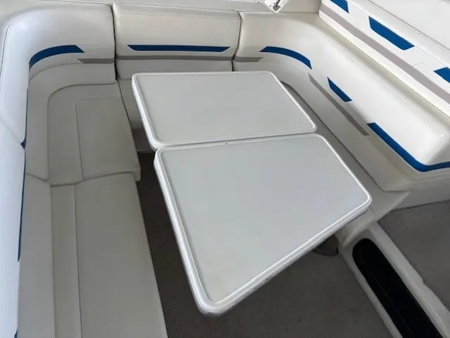 Slide: The Image of 1997 Formula 34PC boat interior with white seating and foldable table. - 6