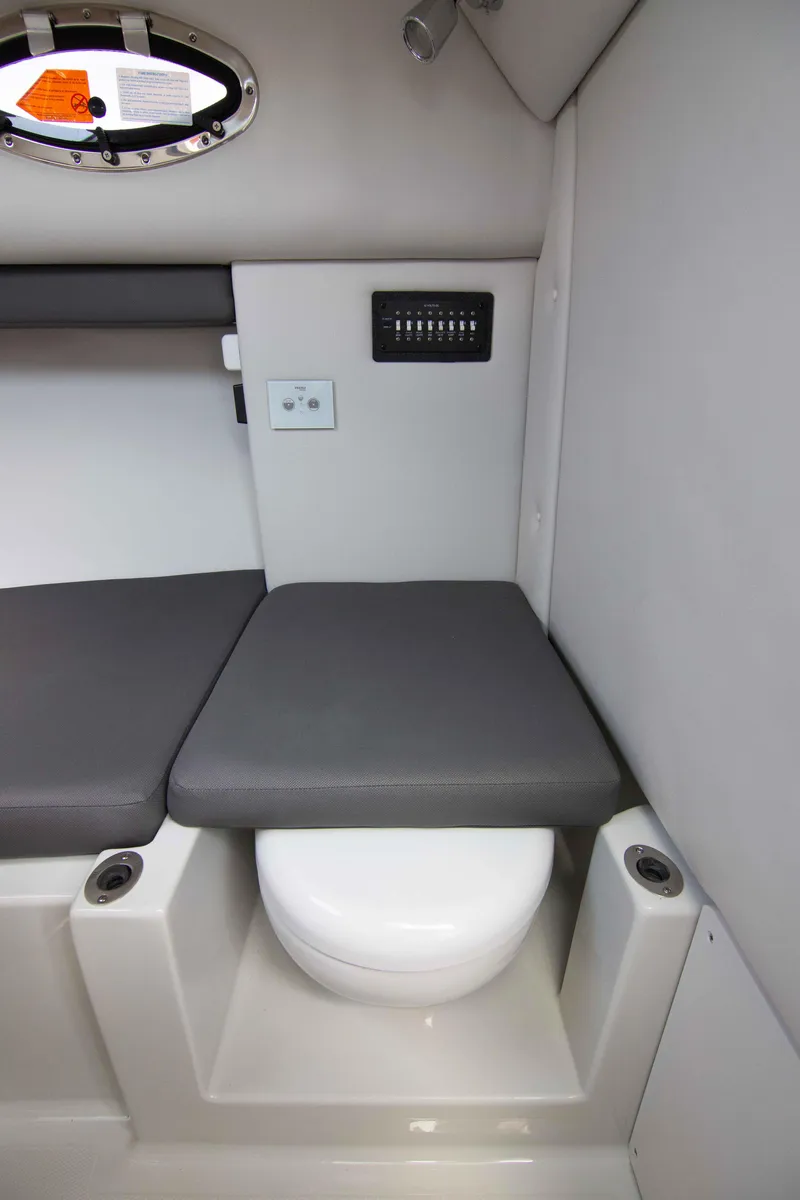 Slide: The Image of 2024 Finseeker 245 WA cabin interior with compact toilet and seating area. - 17