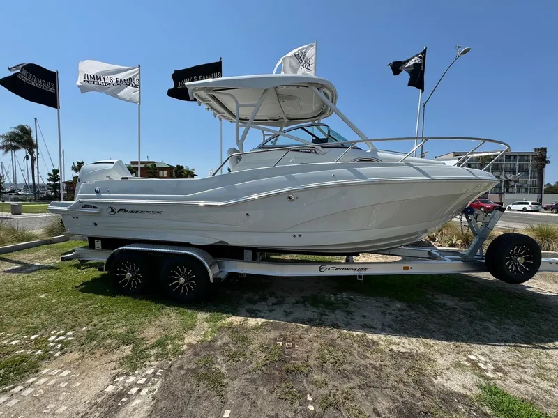 Slide: The Image of 2024 Finseeker 245 WA boat on trailer, displayed outdoors under clear blue sky. - 3