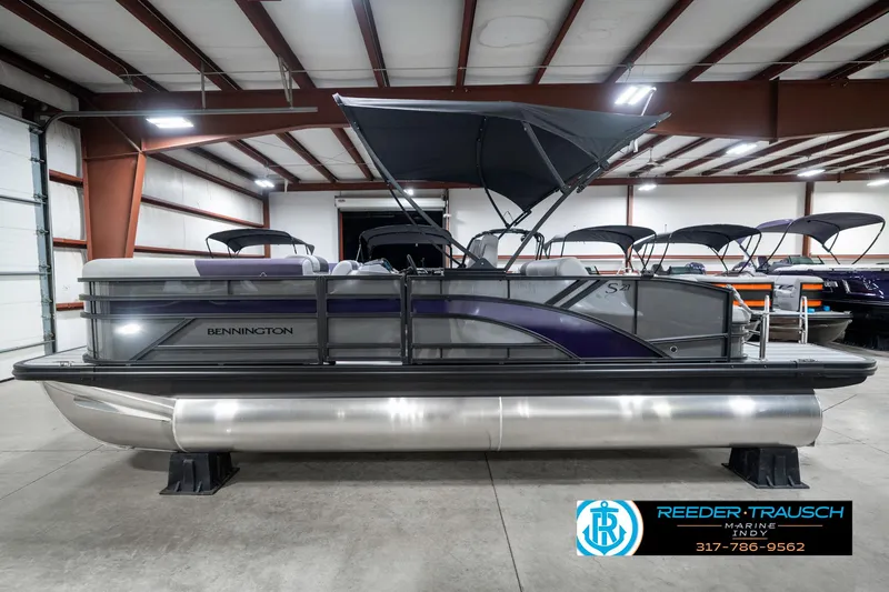Slide: The Image of 2025 Bennington 21 SSB pontoon boat in a showroom with canopy. - 11