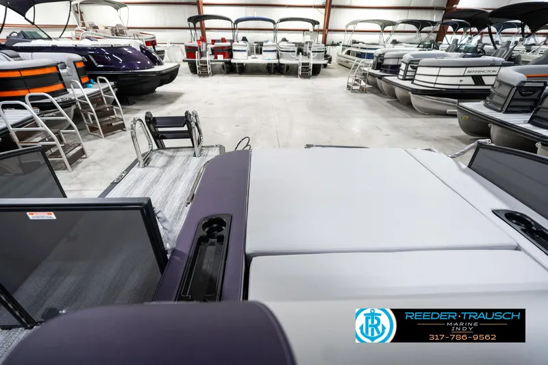 Slide: The Image of 2025 Bennington 21 SSB pontoon boat in showroom with multiple boats displayed. - 18