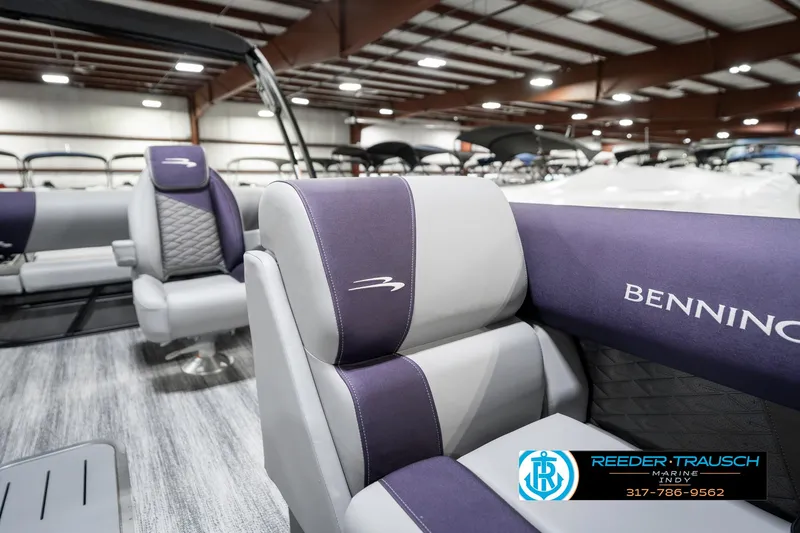 Slide: The Image of 2025 Bennington 21 SSB boat interior with purple and gray seating in showroom. - 24